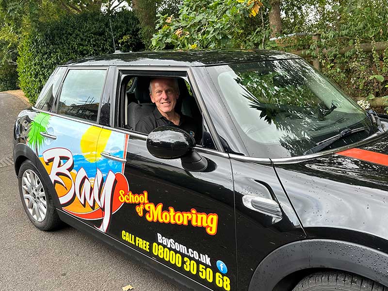 Driving instructor Andy in driving lessong car waiting for student